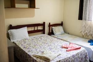a bedroom with two beds with towels on them at Recanto the beach pousada in Iguape +3 photos