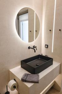 a bathroom with a black sink and a mirror at Xenia Residence in Faliraki +16 photos