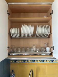 a kitchen with white plates and bowls on a shelf at Entrevías in Albacete