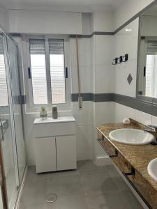 a bathroom with two sinks and a glass shower at Entrevías in Albacete +28 photos