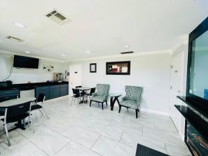 a living room with a table and chairs and a tv at Executive Inn and Suites Houston in Houston