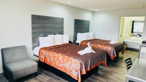 a hotel room with two beds and a chair at Executive Inn and Suites Houston in Houston