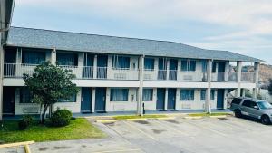 a building with a car parked in a parking lot at Executive Inn and Suites Houston in Houston