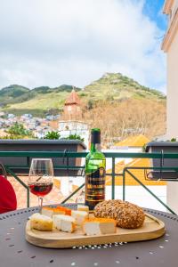 a bottle of wine and cheese and a glass of wine at StayinMachico in Machico