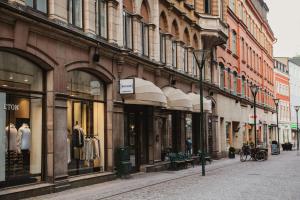 a city street with a bunch of shops on a street at Home Hotel Baltzar in Malmö