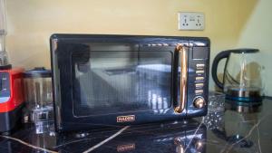 a black microwave oven sitting on top of a counter at cozyairbnb in Otinshi