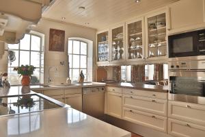 a large kitchen with white cabinets and stainless steel appliances at Private Island De Sayter in Warten