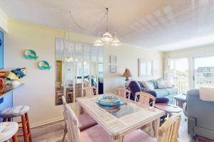 a dining room and living room with a table and chairs at ABPAB167 Blue Haven Beach Retreat in Atlantic Beach