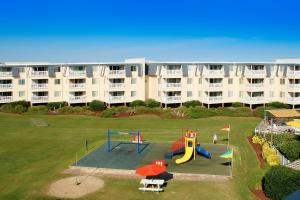 an apartment building with a playground in front of a building at ABPAB167 Blue Haven Beach Retreat in Atlantic Beach