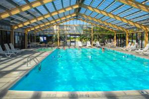 a large swimming pool with people in the water at ABPAB167 Blue Haven Beach Retreat in Atlantic Beach