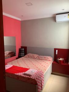 a bedroom with a bed and a red wall at Hotel Lalique in São Paulo +26 photos