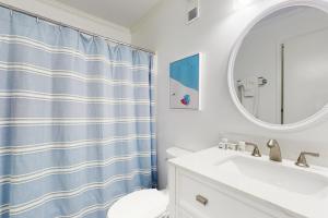 a bathroom with a blue shower curtain and a sink at ABPAB166 Sandy Shores in Atlantic Beach +16 photos
