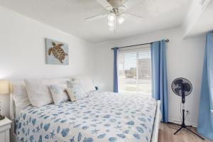 a bedroom with a bed with a ceiling fan and a window at ABPAB166 Sandy Shores in Atlantic Beach