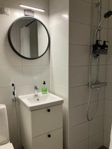 a white bathroom with a sink and a mirror at Yksiö Koulukadulla - autopaikka - Wi-Fi in Seinäjoki +9 photos