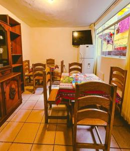 a dining room with a table and chairs and a refrigerator at Ñusta Wasi in Cusco