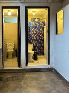 a bathroom with a toilet and a wall at Ñusta Wasi in Cusco