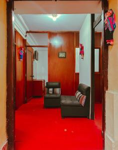 a living room with a red carpet and a couch at Ñusta Wasi in Cusco