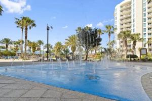 a fountain in a park with palm trees and buildings at 5 Star Resort 11106 Fl Stunning Sunrise 2BR 2BA King Suite,Pools ,Shuttle or Walk to Beach in Destin