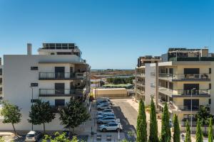 an aerial view of cars parked in a parking lot between two buildings at Santa Maria Apartamentos in Tavira