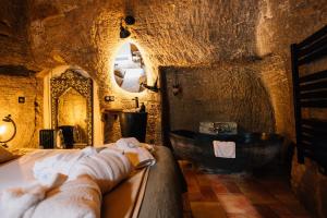 a bathroom with a sink and a tub in a cave at Le Cocon in Doué-la-Fontaine