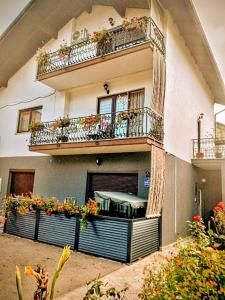 a building with two balconies and flowers on it at Apartmani Hrastik 1 in Bihać