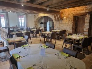 a restaurant with tables and chairs in a room at Logis Hôtel La Fleur de Lys in Cormatin +27 photos