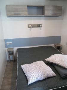 a bedroom with a bed with a blue headboard and two pillows at Camping du Mouchet in La Chapelle-Viviers