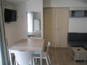 a small apartment with a table and a couch at Camping du Mouchet in La Chapelle-Viviers