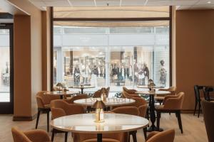 a restaurant with tables and chairs and a large window at Home Hotel Baltzar in Malmö