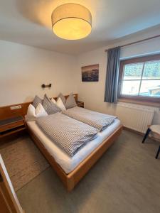 a bedroom with a large bed with a large window at Hof Oberhaus in Kitzbühel