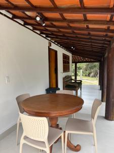 a dining room with a wooden table and chairs at Casa Sol Piscina e Cachoeira in Pirenópolis