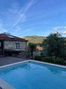 a swimming pool in front of a house at Casa de José in Cabeceiras de Basto