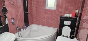a red tiled bathroom with a tub and a toilet at Azul in Bihać