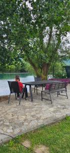 a man sitting at a picnic table next to a lake at Azul in Bihać +22 photos