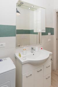 a bathroom with a sink and a mirror at Cala Lupo Relax Veranda e BBQ nel verde in Stintino +16 photos
