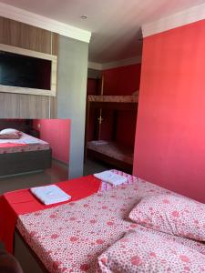 a bedroom with two beds and a red wall at Hotel Lalique in São Paulo