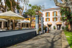 a street with tables and umbrellas and a building at StayinMachico in Machico