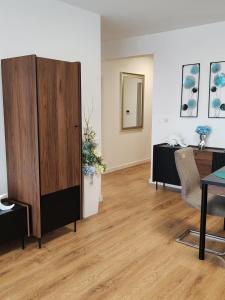 a living room with a large wooden cabinet and a table at Sunny apartment208 in Dunajská Streda