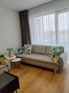 a living room with a couch and a large window at Sunny apartment208 in Dunajská Streda