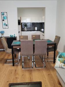 a dining table and chairs in a living room at Sunny apartment208 in Dunajská Streda