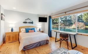 a bedroom with a bed and a desk and a window at Cozy Studio Cottage on the River in Bend