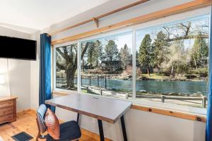 a room with a table and a large window at Cozy Studio Cottage on the River in Bend +30 photos