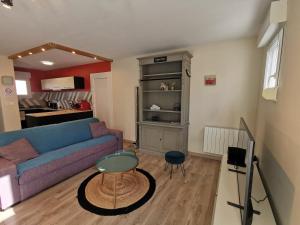 a living room with a couch and a table at La coccinelle in Gujan-Mestras