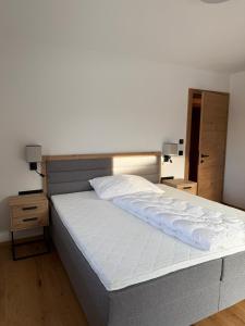 a bedroom with a large bed with white sheets at Apartment Kirchfeld in Aurach bei Kitzbuhel