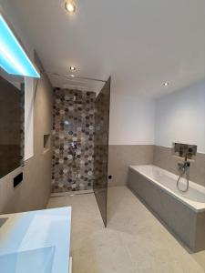 a bathroom with a shower and a bath tub at Apartment Kirchfeld in Aurach bei Kitzbuhel
