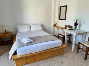 a bedroom with a bed and a desk and a table at Limnes Seaside Studio in Ligaridia
