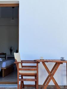 a wooden table and a chair next to a bed at Limnes Seaside Studio in Ligaridia