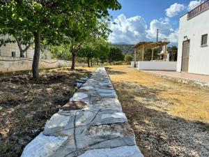 a stone path in a yard next to a building at Limnes Seaside Studio in Ligaridia +7 photos