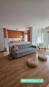 a living room with a couch and a kitchen at Maia Surf House - Baleal in Ferrel