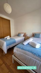 two beds in a room with blue and white at Maia Surf House - Baleal in Ferrel
